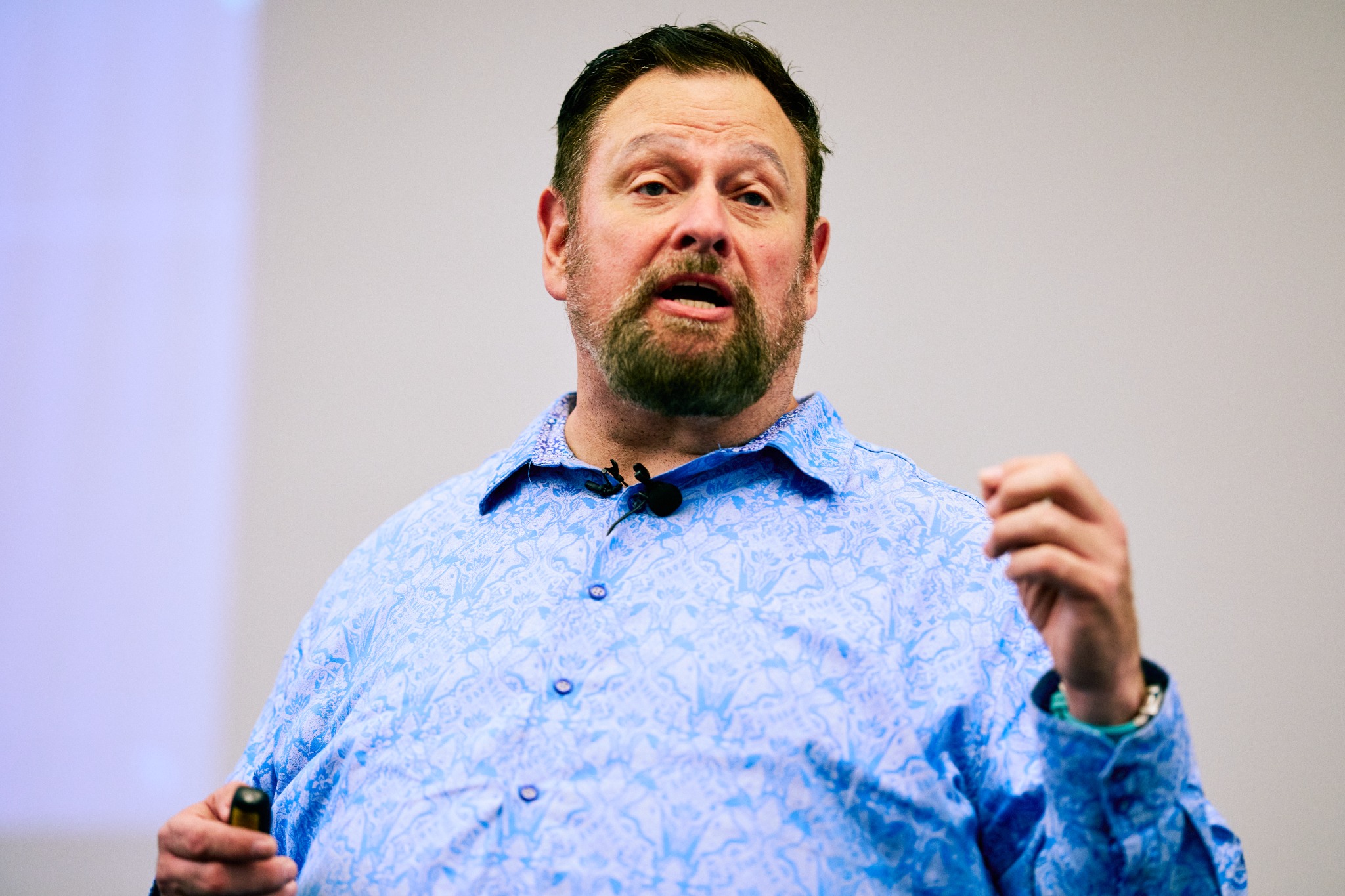 Wally Bressler addressing an audience with a presentation clicker